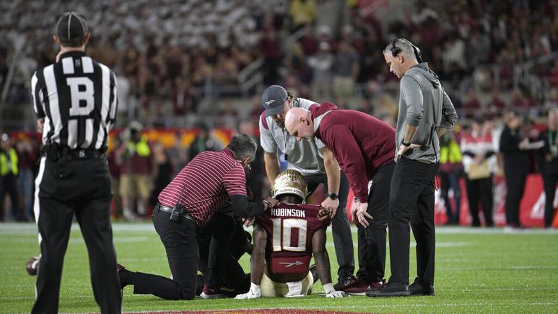 Florida State defensive back Jammie Robinson (10) is helped after getting injured on a play...