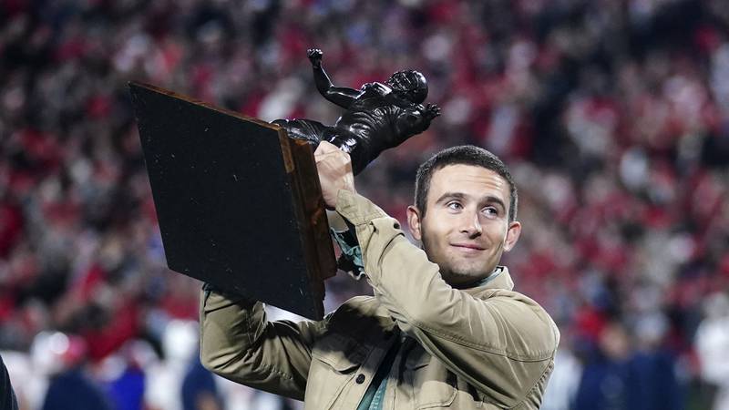 Former Georgia and current Los Angeles Rams quarterback Stetson Bennett holds a trophy as he is...