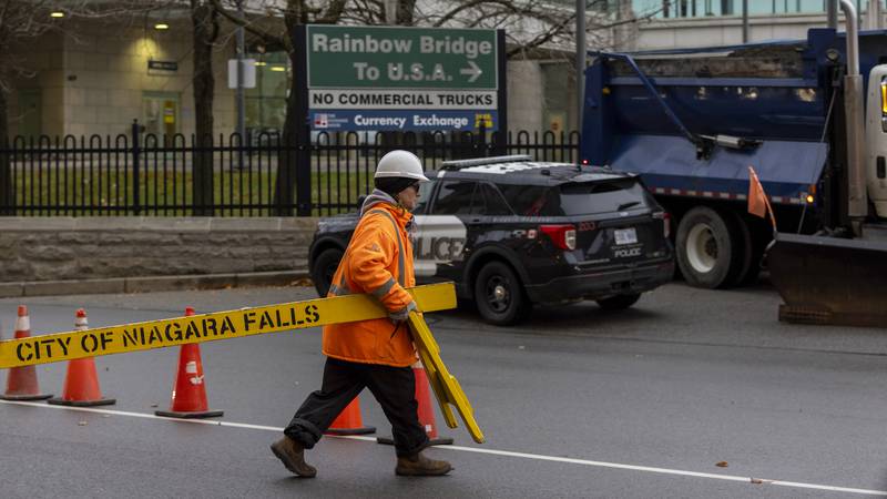 Workers block the entrance to the Rainbow Bridge border crossing between the U.S. and Canada,...